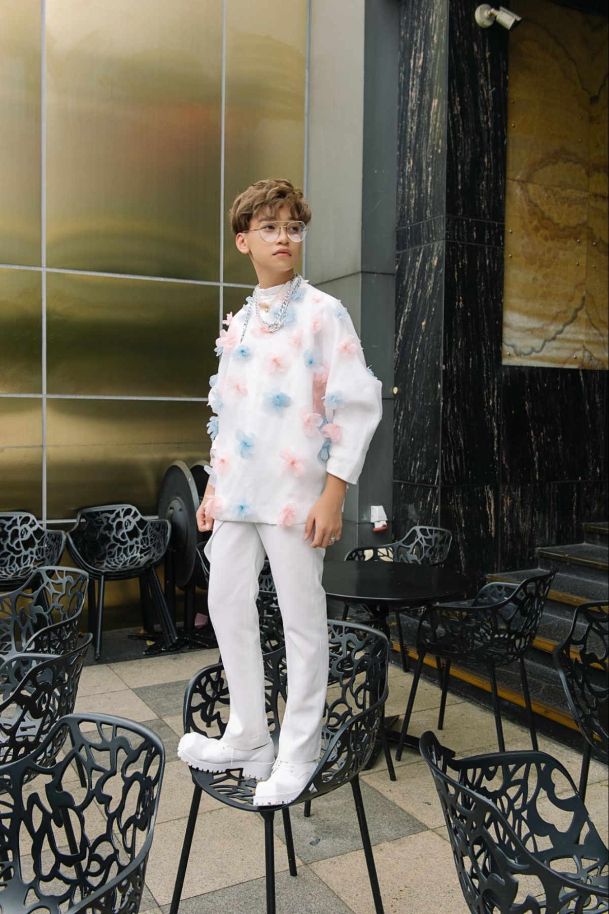 Cao Hữu Nhật trong chiếc áo được đính kết bằng những bông hoa màu xanh, hồng pastel. Với thiết kế tay lửng, cổ cao, mặc dù họa tiết khá “nhẹ nhàng” nhưng khi mẫu teen Cao Hữu Nhật khoác lên người rất hợp lý và đẹp mắt.