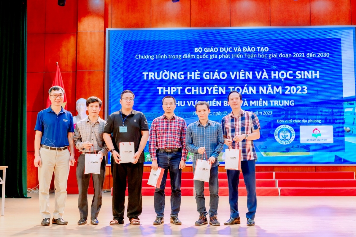 TS Lê Minh Hà - Giám đốc điều hành Viện Nghiên cứu cao cấp về Toán ( bìa trái ) tặng quà lưu niệm cho các thầy giáo đại diện cho các trường THPT chuyên khu vực miền Bắc có học sinh tham gia Trường hè toán học 2023
