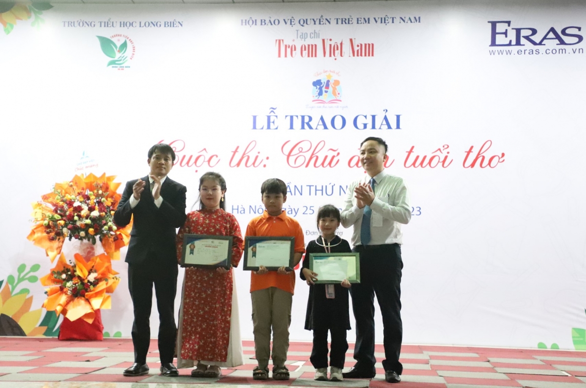 Ông Nguyễn Mạnh Huy, Tổng Biên tập Tạp chí Trẻ em Việt Nam - Trưởng Ban Tổ chức cuộc thi “Chữ đẹp tuổi thơ” lần thứ nhất và ông Phan Văn Cường - Giám đốc Công ty TNHH ERAS Thanh Chương trao giải Nhất cho 3 thí sinh