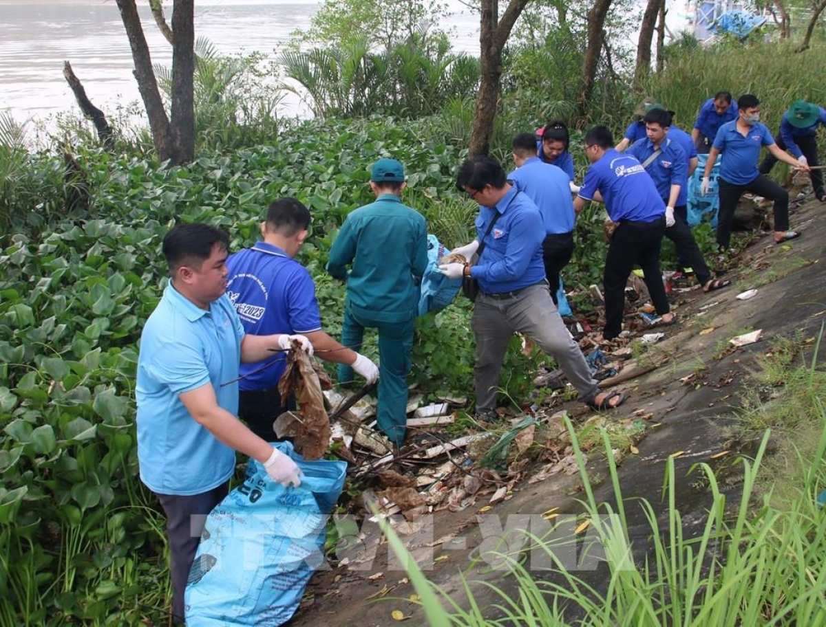 Thanh niên cung tay dọn rác