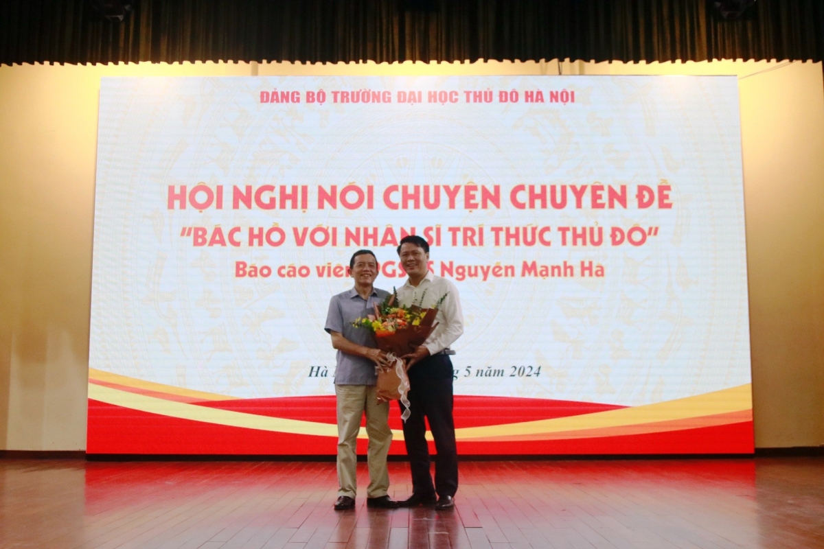 PSG.TS Nguyễn Văn Tuân, Phó Hiệu trưởng Trường Đại học Thủ đô Hà Nội (bên phải) tặng hoa PGS.TS Nguyễn Mạnh Hà, nguyên Viện trưởng Viện Lịch sử Đảng Học viện Chính trị Quốc gia Hồ Chí Minh (bên trái)