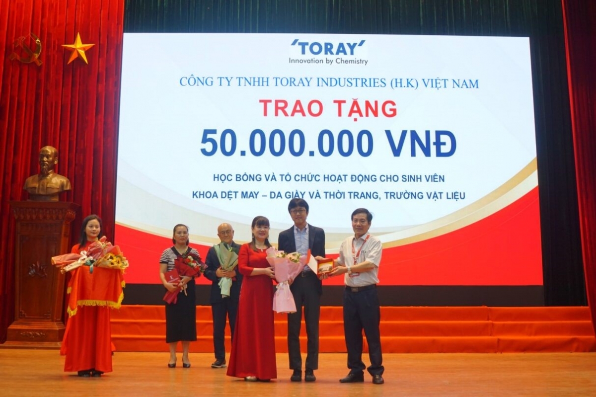Ông Akihiro Suzuki, giám đốc Công Ty TNHH Toray Industries (H.K.) nhận quà lưu niệm từ lãnh đạo nhà trường.