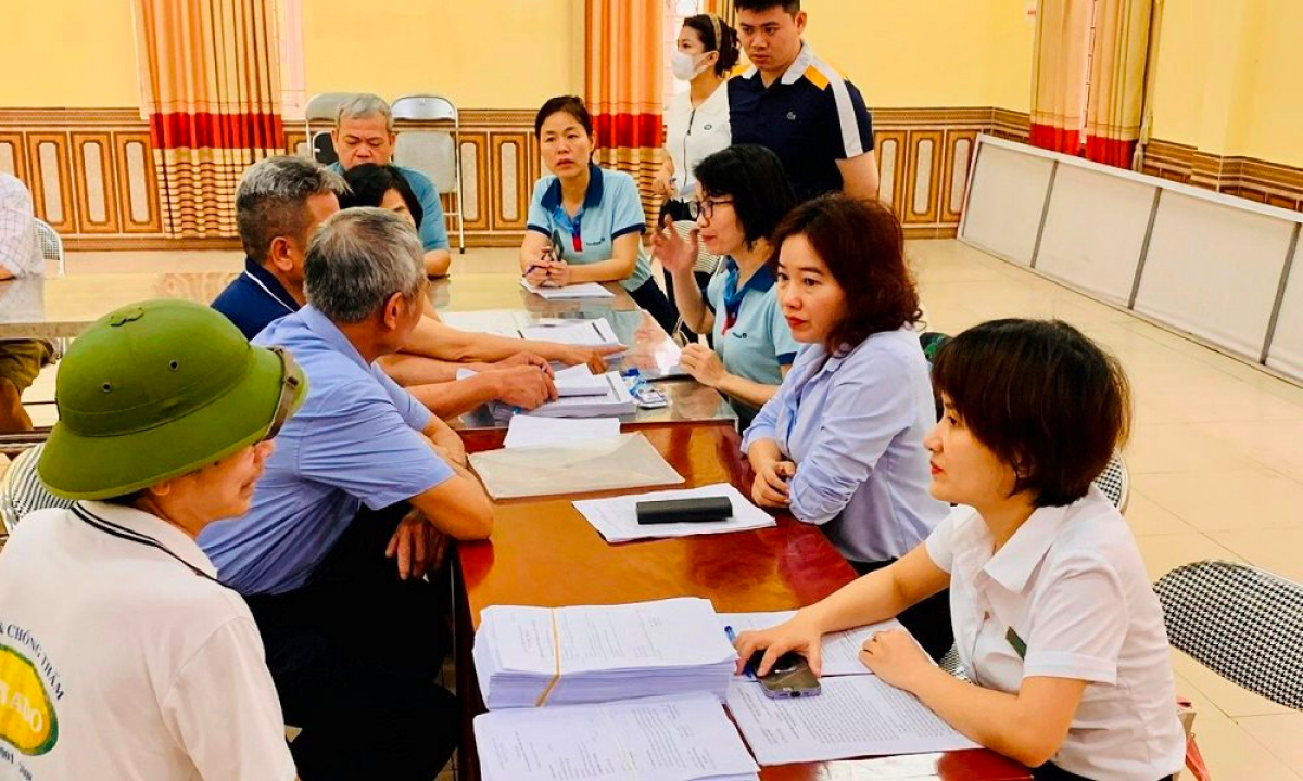 Cán bộ bảo hiểm xã hội quận Cầu Giấy (Hà Nội) vận động, tuyên truyền người dân chuyển sang hình thức nhận lương hưu qua ATM