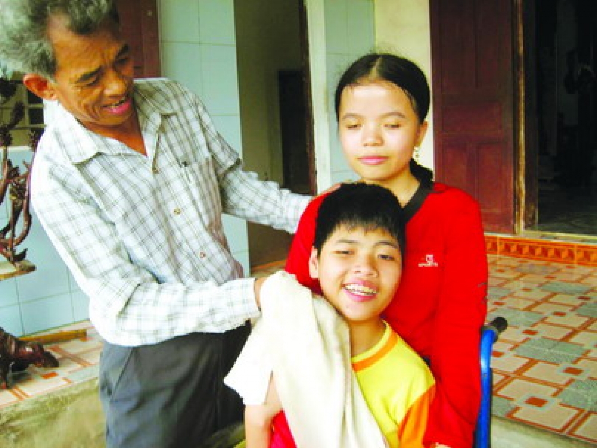 Ông Địu chăm sóc cho hai người con bị tật nguyền do di chứng chất chật da cam từ cha