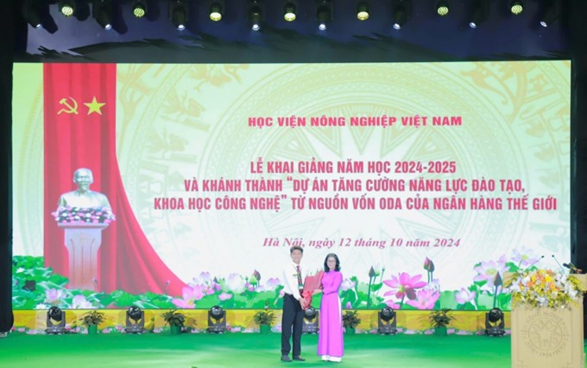 Sinh viên Hoàng Anh, lớp K69LOGISE, ngành Logistics và Quản lý chuỗi cung ứng đại diện cho các bạn tân sinh viên khoá 69 và gần 30.000 sinh viên Học viện tặng hoa cho GS.TS Nguyễn Thị Lan - Giám đốc HVNNVN