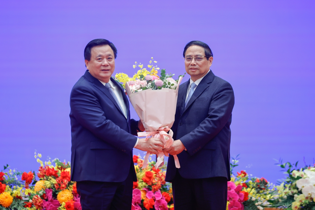 đồng chí Nguyễn Xuân Thắng, Ủy viên Bộ Chính trị, Chủ tịch Hội đồng Lý luận Trung ương, Giám đốc Học viện Chính trị Quốc gia Hồ Chí Minh tặng hoa chúc mừng Thủ tướng Phạm Minh Chính