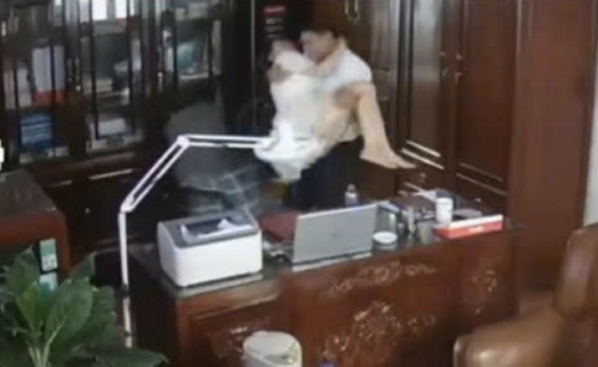 Hình ảnh người đàn ông "thân mật" với một người phụ nữ tại phòng làm việc (Ảnh cắt từ clip)