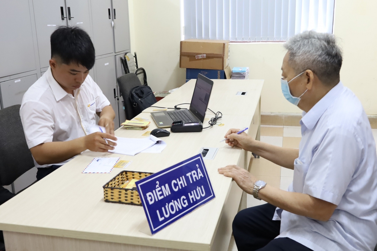 Người hưởng chế độ hưu trí làm thủ tục tại điểm chi trả. Ảnh: Cơ quan BHXH cung cấp